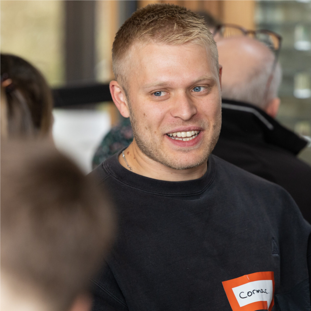 Cormac, a participant at The Big Day Out 2023 smiles while in conversation during a breakout session at the annual gathering.